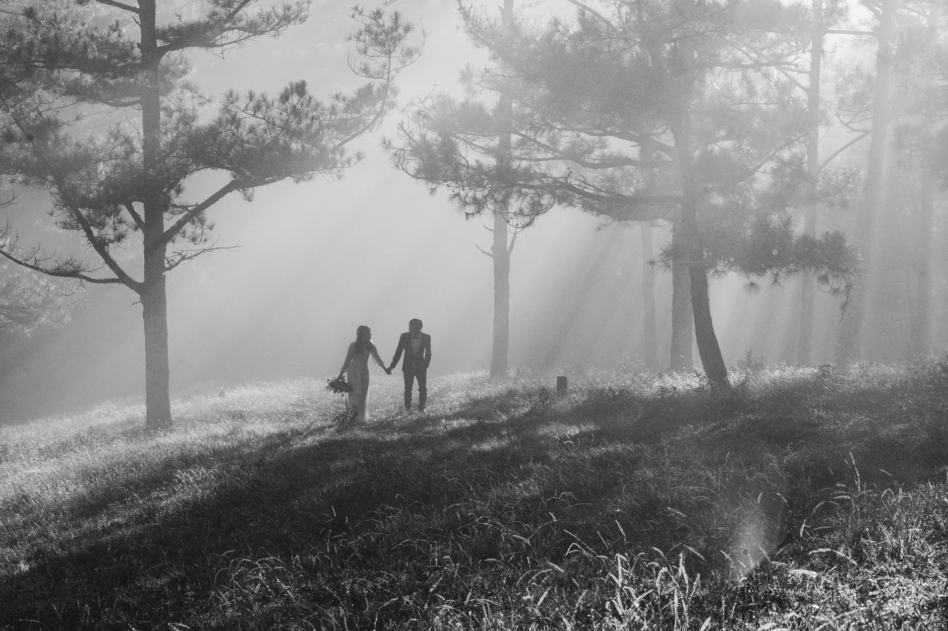 grayscale photography of man and woman holding hands